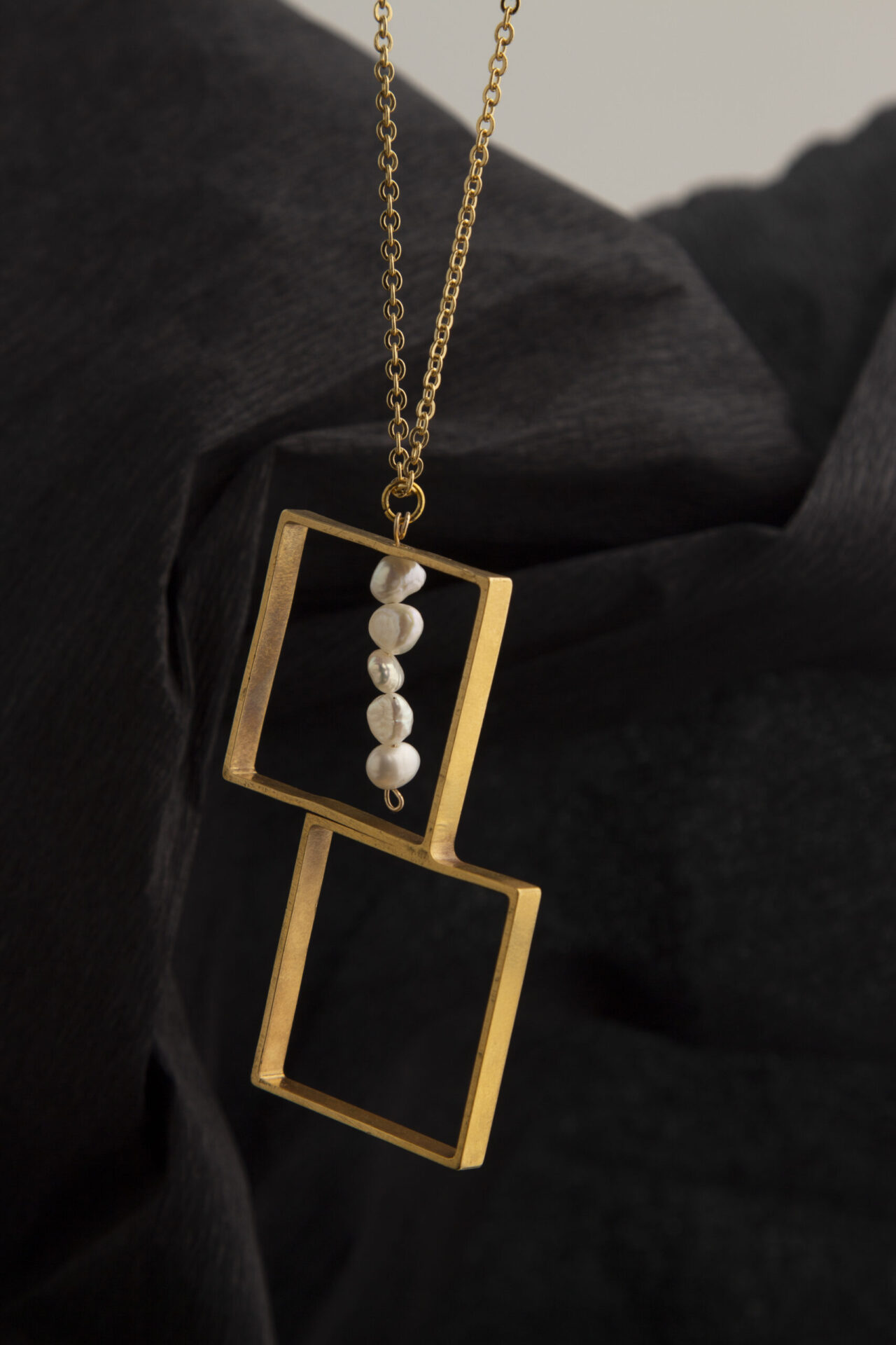 Gold-Plated squares necklace with a line of pearls.