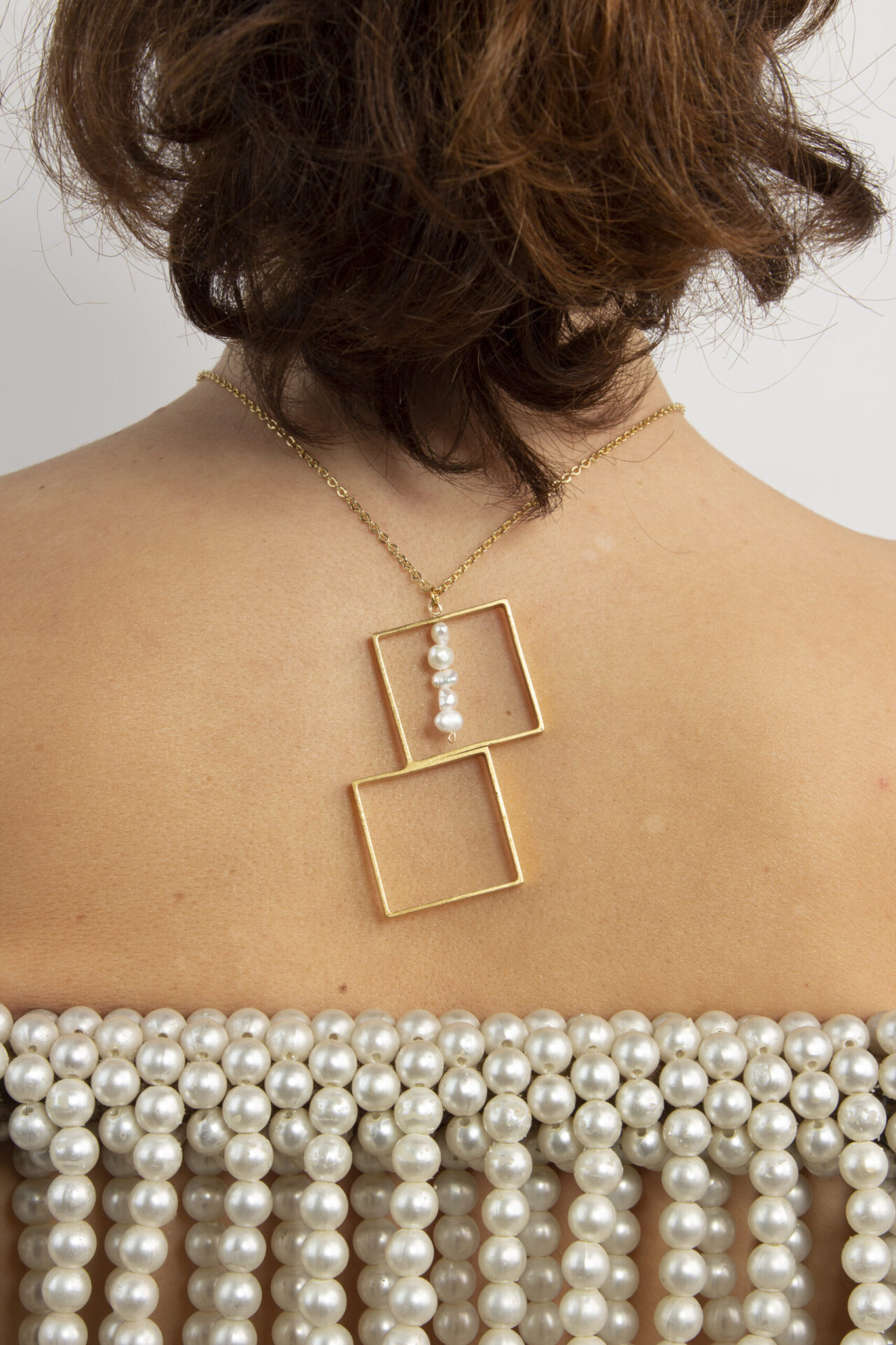 Gold-Plated squares necklace with a line of pearls.